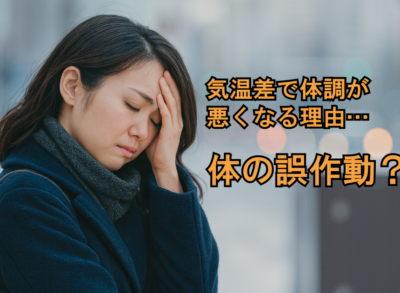 気温差で体調が悪くなり頭痛に悩む女性の写真